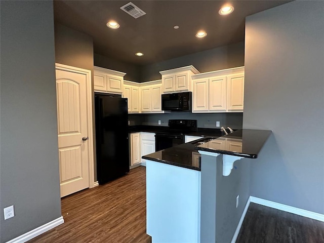 kitchen featuring dark countertops, white cabinetry, visible vents, and black appliances