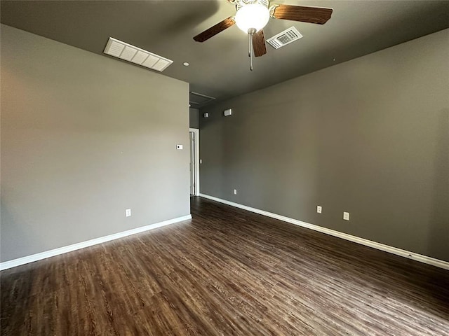 unfurnished room with dark wood-style floors, ceiling fan, visible vents, and baseboards