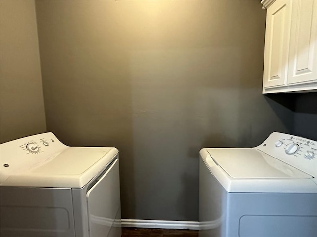 laundry room with cabinet space, baseboards, and independent washer and dryer