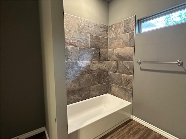 full bathroom with bathtub / shower combination, wood finished floors, and baseboards