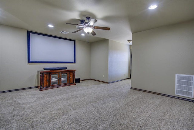 cinema with ceiling fan, visible vents, and light colored carpet