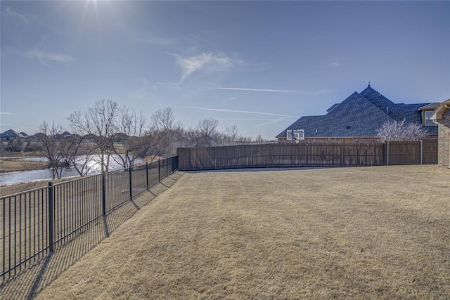 view of yard with a water view and fence