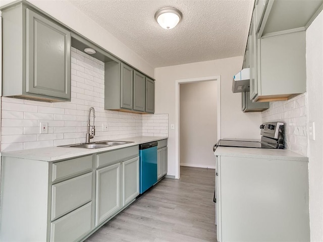 kitchen featuring stainless steel appliances, a sink, light wood-style floors, light countertops, and backsplash