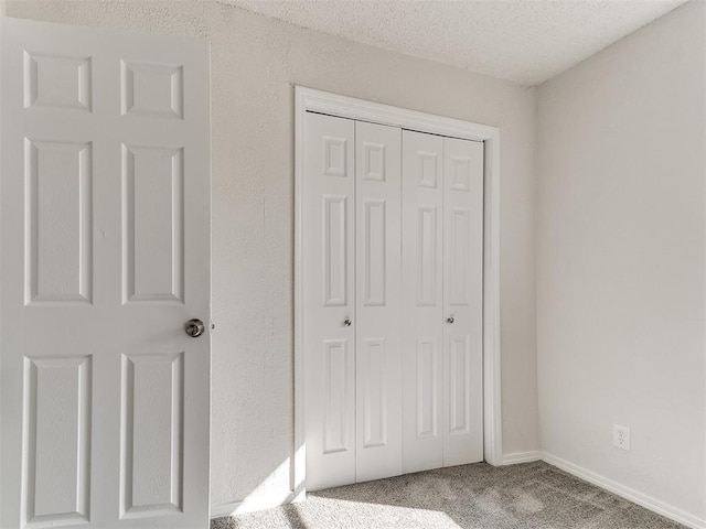 unfurnished bedroom with a closet, carpet flooring, and a textured ceiling