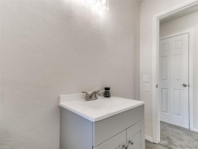 bathroom with a textured wall and vanity