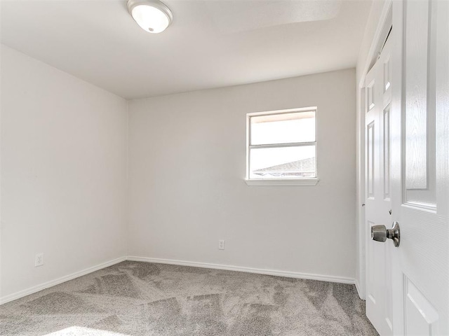 unfurnished room featuring baseboards and light colored carpet