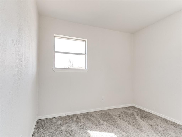 empty room featuring carpet floors and baseboards