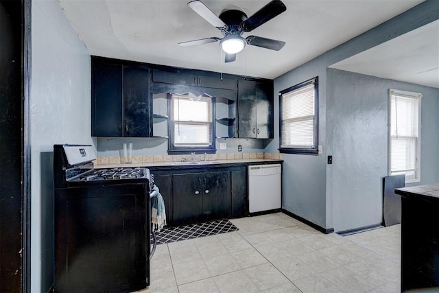 kitchen with gas stove, dark cabinetry, dishwasher, and a sink