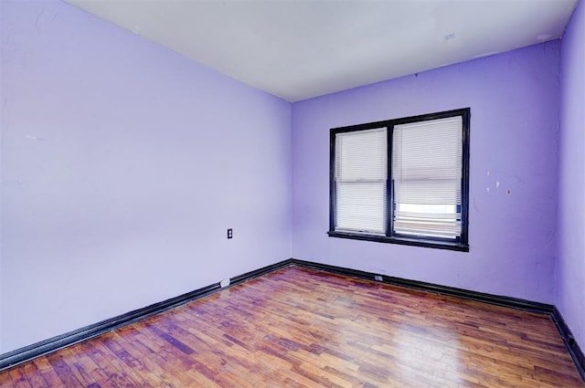 empty room featuring wood finished floors and baseboards