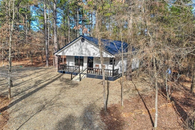 rustic home featuring a porch and driveway