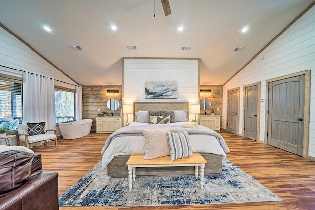 bedroom featuring wood walls, visible vents, and wood finished floors