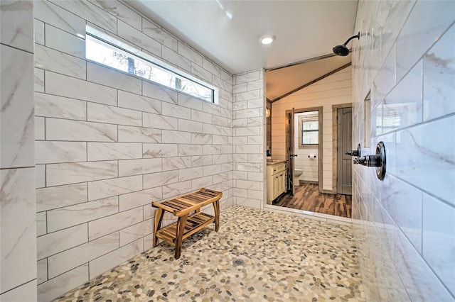 bathroom with toilet, tile patterned flooring, a tile shower, tile walls, and recessed lighting