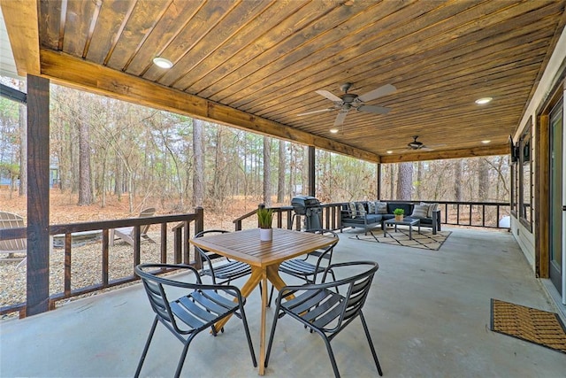 unfurnished sunroom featuring a ceiling fan and wooden ceiling