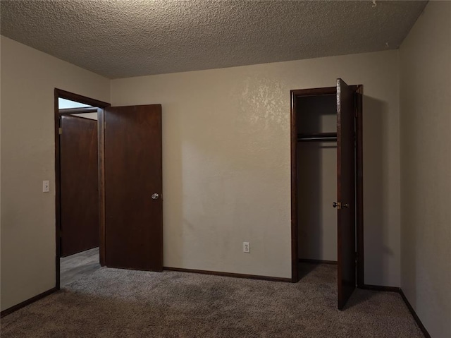 unfurnished bedroom featuring carpet, a textured ceiling, and baseboards