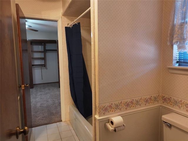 full bathroom featuring wallpapered walls, shower / bath combination with curtain, toilet, and tile patterned floors