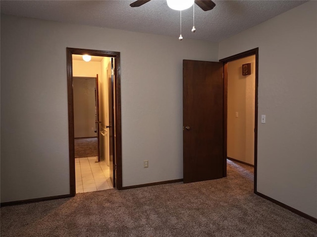 unfurnished bedroom with carpet, ensuite bathroom, ceiling fan, a textured ceiling, and baseboards