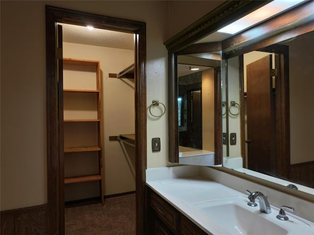 bathroom featuring a walk in closet and vanity