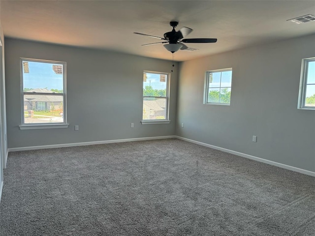 unfurnished room with carpet floors, baseboards, visible vents, and ceiling fan