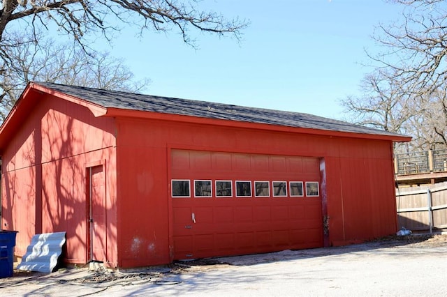 detached garage featuring fence