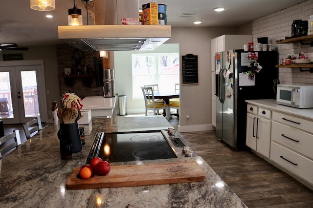 kitchen featuring open shelves, white microwave, exhaust hood, and stainless steel refrigerator with ice dispenser