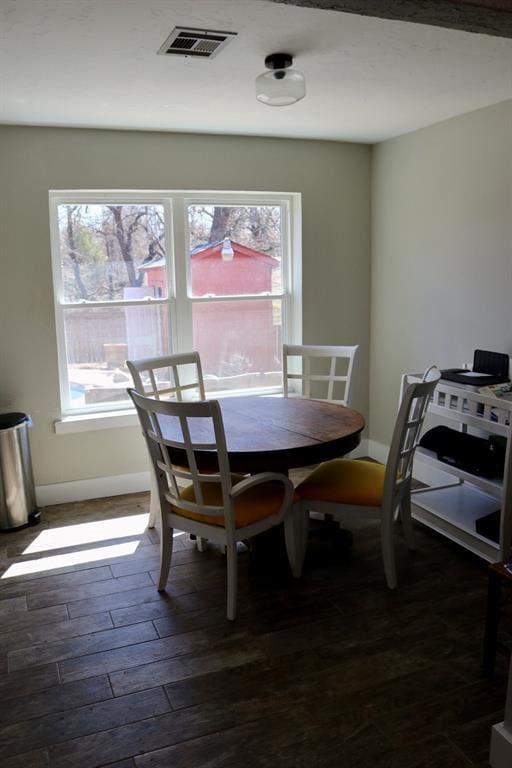 dining space with visible vents, baseboards, and dark wood finished floors