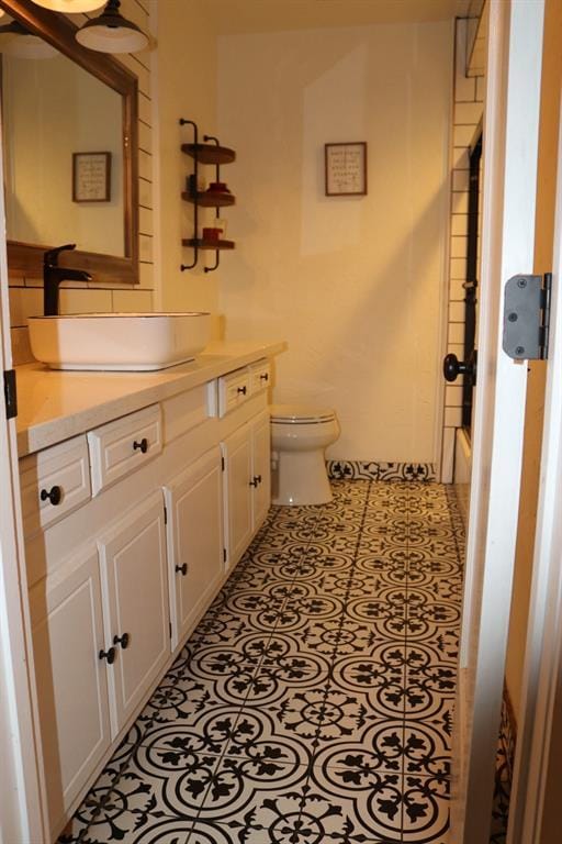 bathroom with toilet, a tub to relax in, tile patterned flooring, walk in shower, and vanity