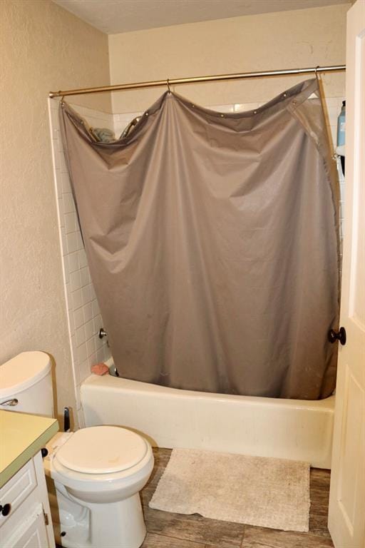 full bath with toilet, shower / bath combo with shower curtain, vanity, and wood finished floors