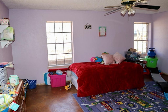 bedroom with a ceiling fan, concrete floors, and a textured ceiling