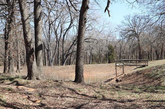 view of yard featuring a forest view and fence