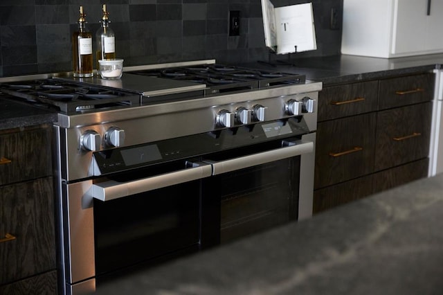 kitchen featuring dark countertops, dark brown cabinetry, double oven range, and decorative backsplash