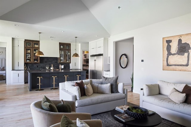 living room featuring vaulted ceiling, recessed lighting, and light wood-style floors