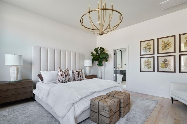 bedroom featuring visible vents, baseboards, ensuite bathroom, light wood-type flooring, and a chandelier