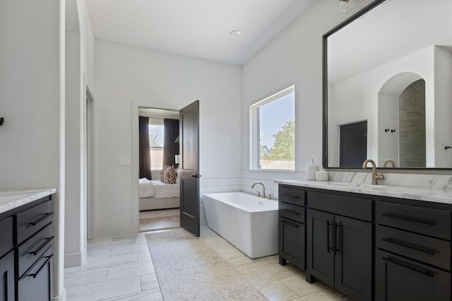 ensuite bathroom with a freestanding bath, vanity, and ensuite bathroom