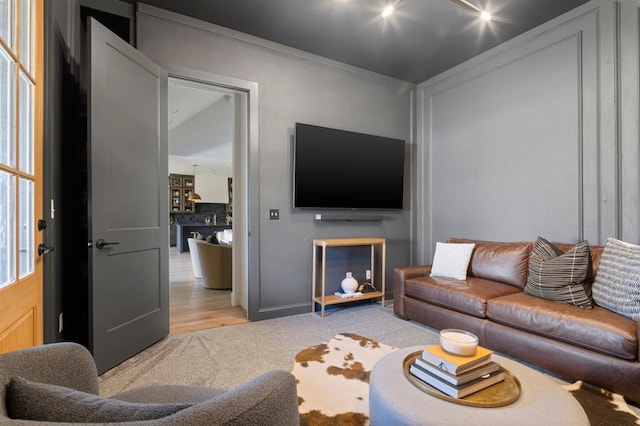 living area with light colored carpet and crown molding