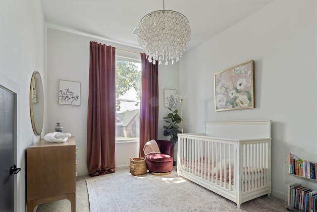 bedroom with a crib, a chandelier, and light colored carpet