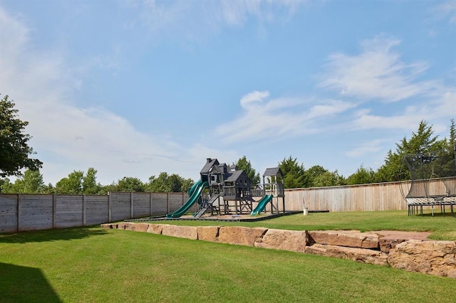 view of jungle gym with a trampoline, a fenced backyard, and a lawn