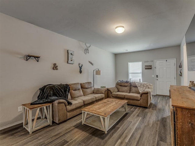 living area featuring baseboards and dark wood-type flooring