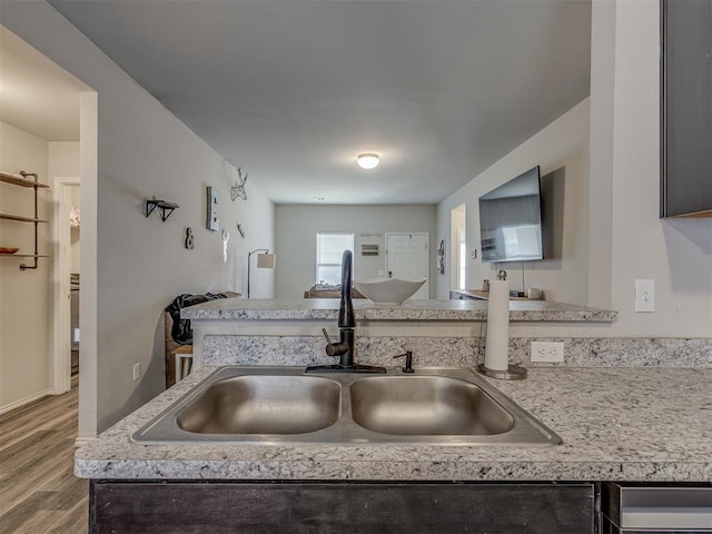 kitchen featuring light wood-type flooring, light countertops, and a sink