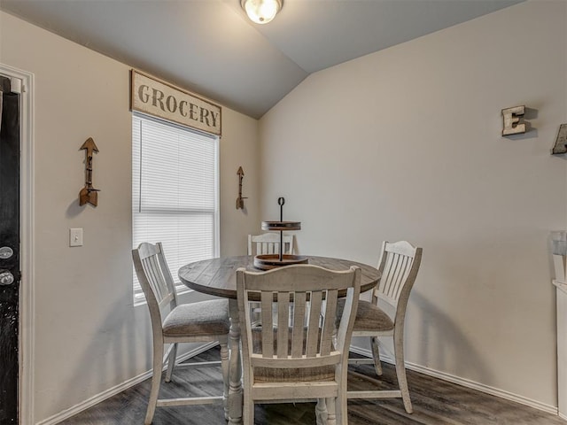 dining space featuring lofted ceiling, dark wood-style flooring, and baseboards