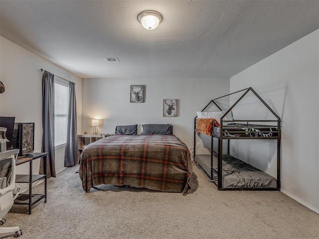 bedroom with light carpet, visible vents, and baseboards