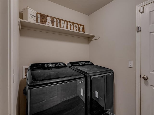 clothes washing area featuring laundry area and washer and clothes dryer