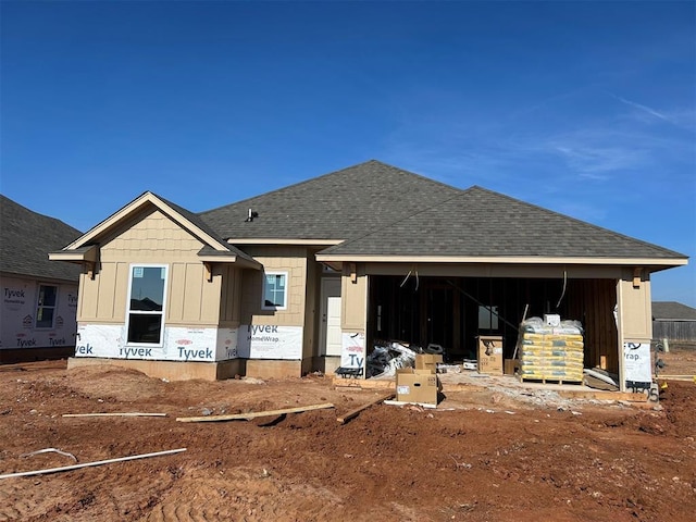 back of property with an attached garage, a shingled roof, and board and batten siding