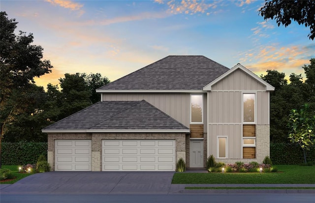 view of front of property featuring a shingled roof, concrete driveway, a lawn, and a garage