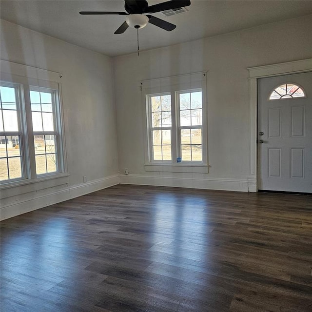 entryway with baseboards, visible vents, ceiling fan, and dark wood-type flooring