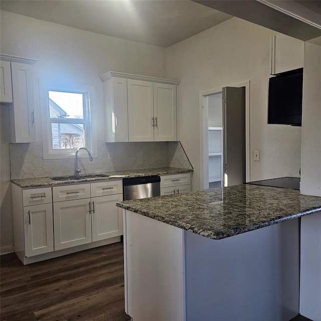 kitchen featuring a peninsula, dark stone counters, a sink, white cabinetry, and dishwasher