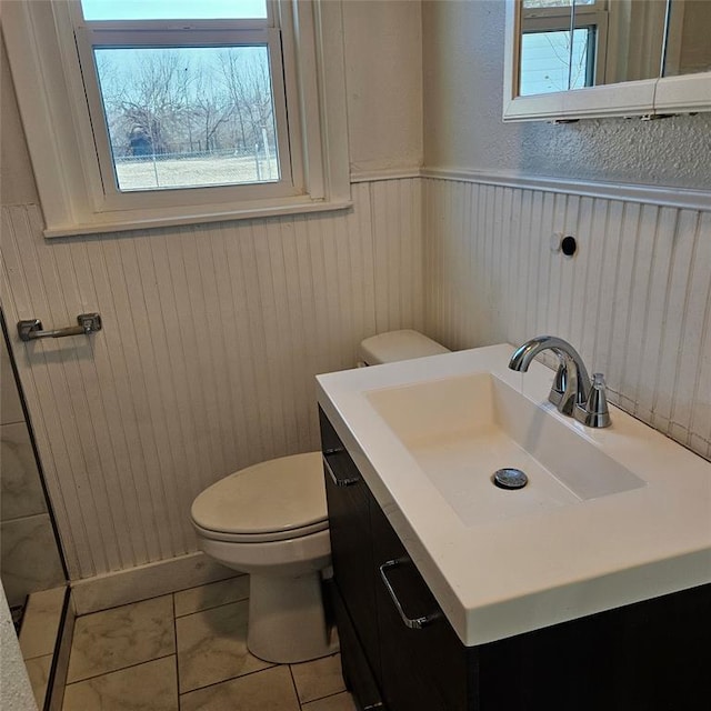 bathroom with toilet, wainscoting, and vanity