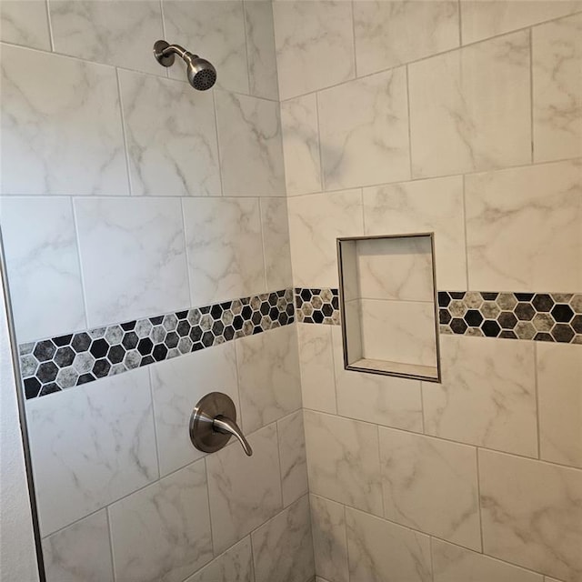 interior details with a tile shower