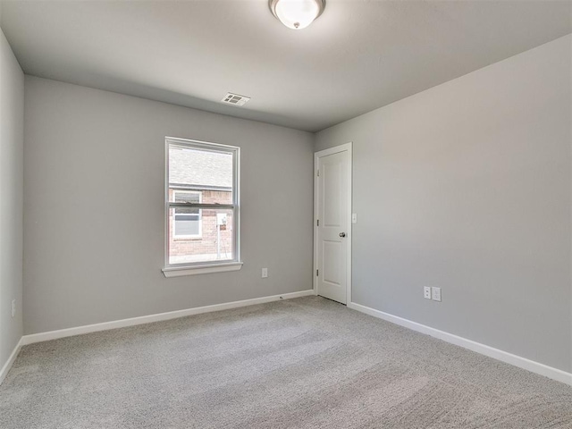carpeted empty room featuring visible vents and baseboards