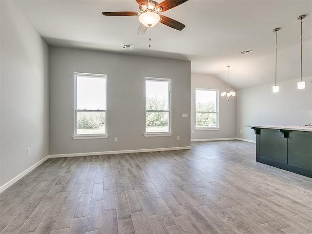 unfurnished living room featuring light wood-style flooring, visible vents, and ceiling fan with notable chandelier