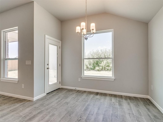 interior space with a chandelier, light wood-style flooring, and baseboards